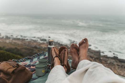 Picture of couples toes on the beach.